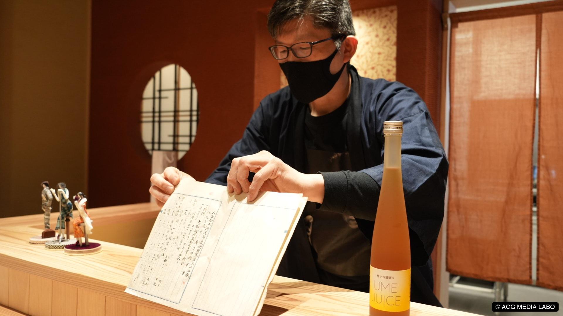梅ヶ谷酒造に残る古い帳面を開く様子